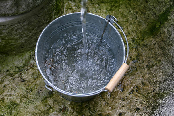 bucket with pouring water close up stock photo