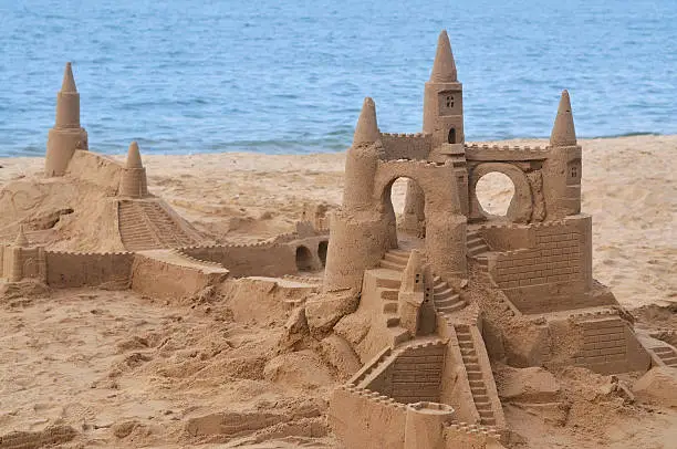 Sandcastle by the sea with copy space provided.