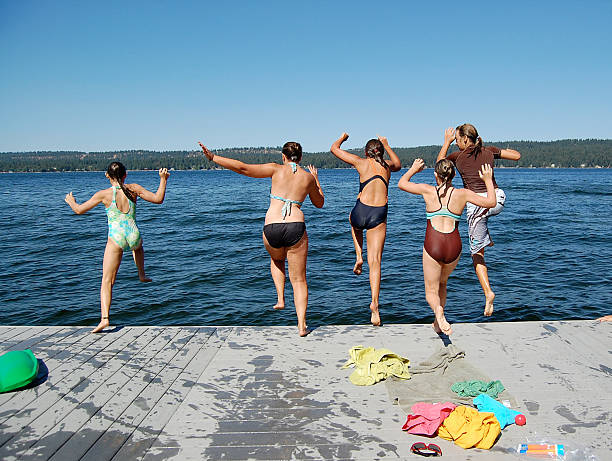 istock Women in bathing suits jumping off the dock 172848963