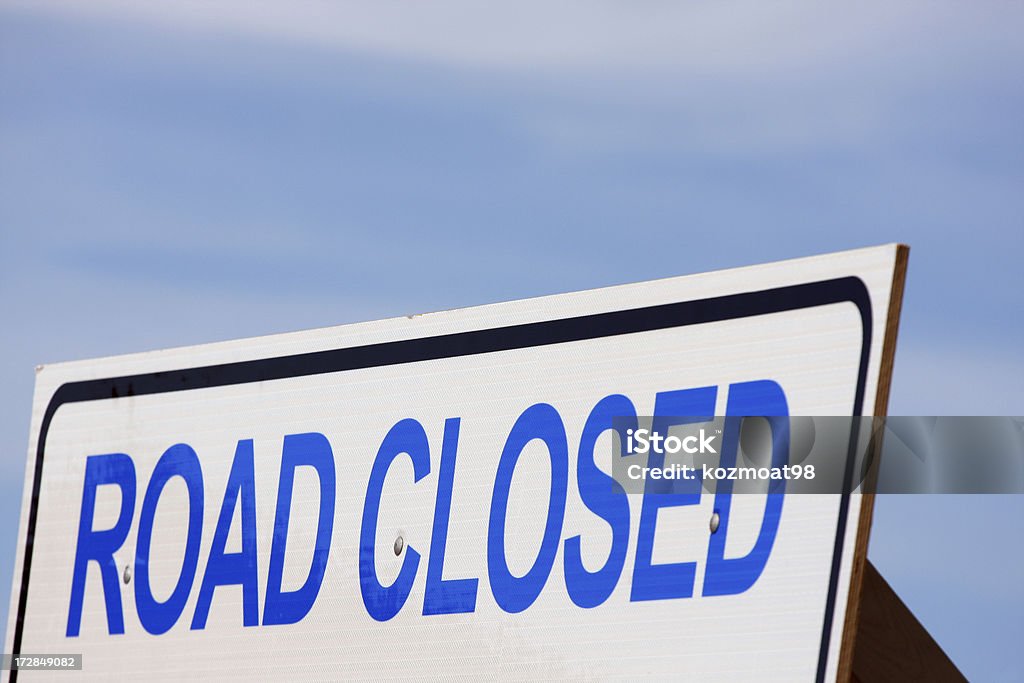 Road Closed Sign Road closed sign shot against a blue sky. Shallow DOF with focus on the centre. Close-up Stock Photo