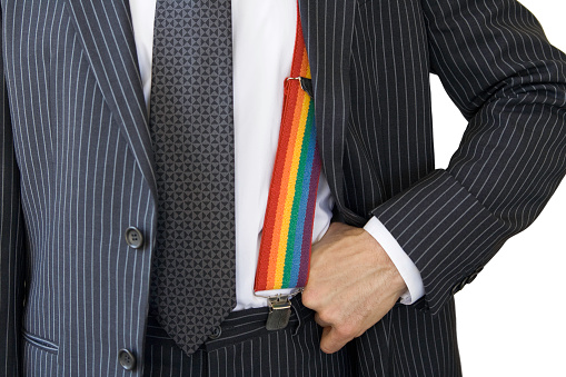 Rainbow suspenders beneath blue pinstripe jacket. Shallow DOF, focus on suspenders