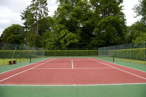 hard tennis court (ashfelt surface) set in landscaped grounds