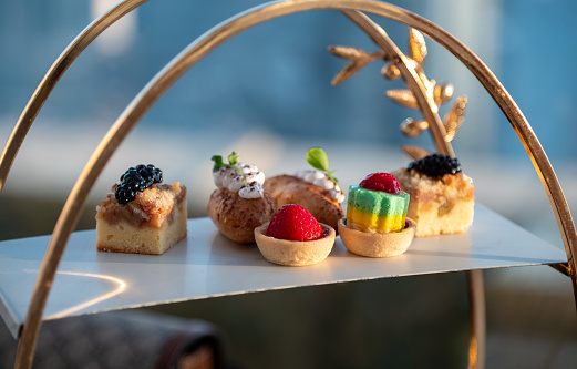 Tea and sweets. Traditional afternoon tea with a selection of deserts from a high display of sweet treats at elegant restaurant