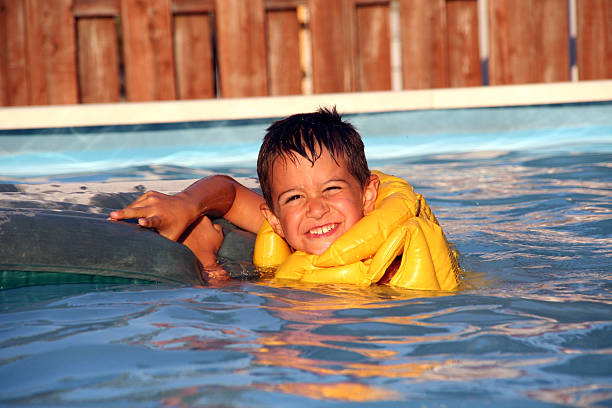 criança vestindo uma jaqueta amarela na piscina - life jacket equipment safety jacket - fotografias e filmes do acervo