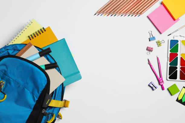 istock Backpack with different school stationery on white background, flat lay. Space for text 1728515033