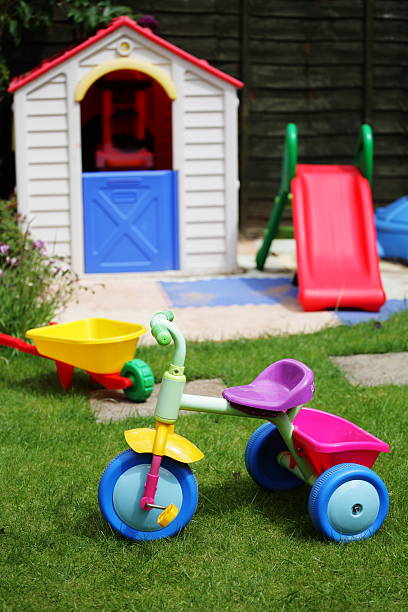 Old retro rusty children's tricycle standing on green grass