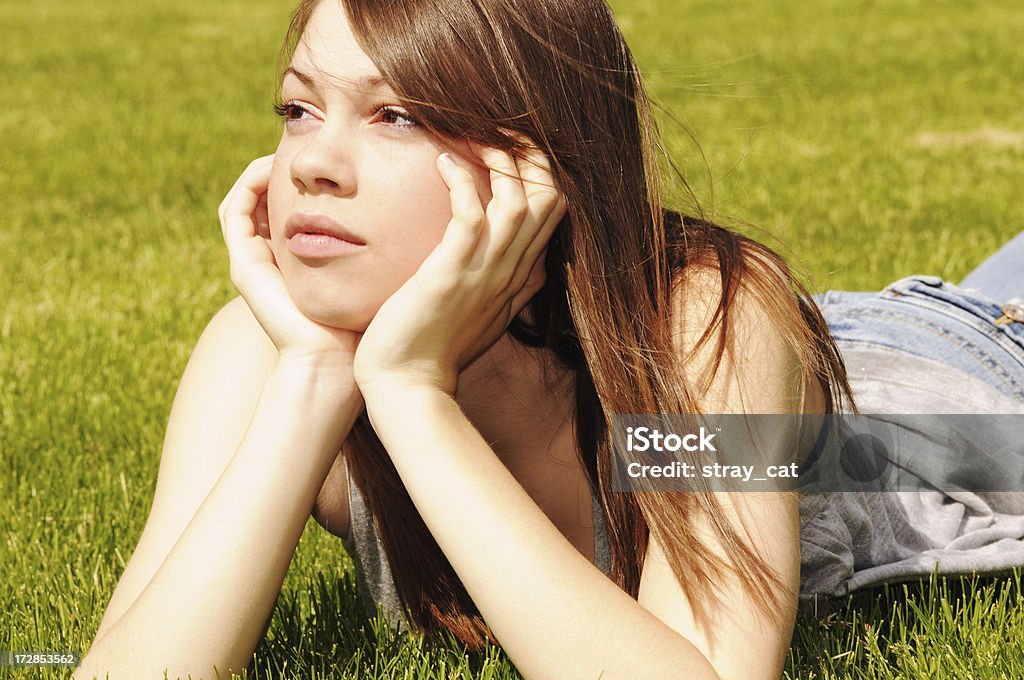 Dreamy Teen A pretty fourteen-year-old girl is daydreaming in a meadow. 14-15 Years Stock Photo