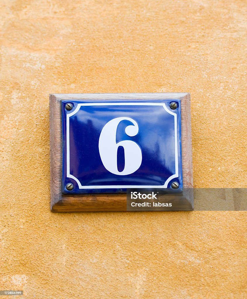 Número 6, seis. Esmalte azul placa na parede amarela. - Foto de stock de Amarelo royalty-free