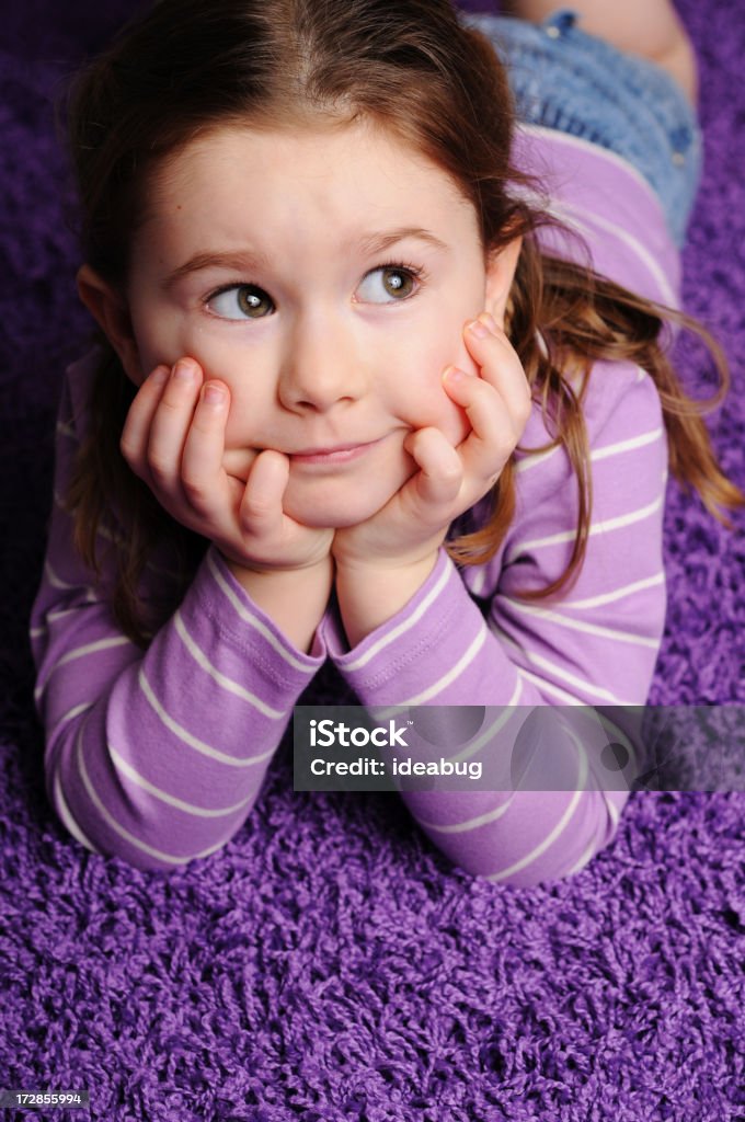 少女ながらのまどろみのひとときに横たわるパープルのカーペット - 4歳から5歳のロイヤリティフリーストックフォト