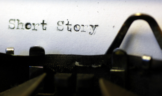 The words 'short story' picked out on a grungy old typewriter. Macro image.