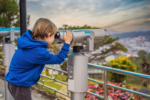 Binoscope. Stationary city binoculars. A boy looks at the city through a binoscope.