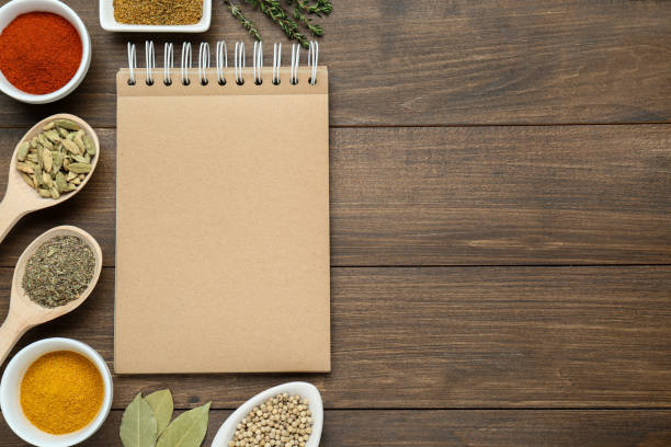 istock Blank recipe book and different ingredients on wooden table, flat lay. Space for text 1728565941