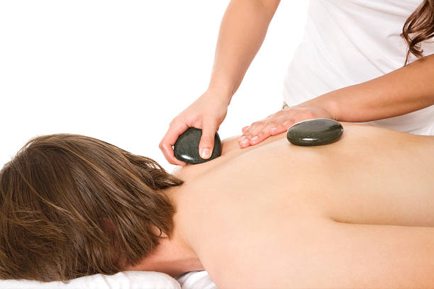 massagem com pedras quentes - massage therapist stone spa treatment working - fotografias e filmes do acervo