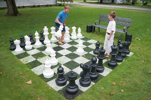 Young boys playing lawn chess.