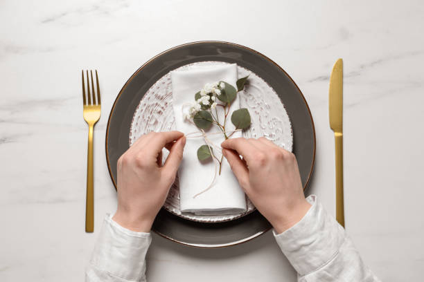 istock Woman decorating setting with eucalyptus leaves at white marble table, top view 1728570680