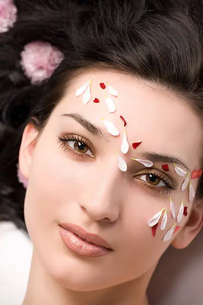 Close-up of beautiful face with rose-petals and  flowers