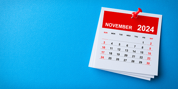 White Sticky Note With 2024 November Calendar And Red Push Pin On Blue Background
