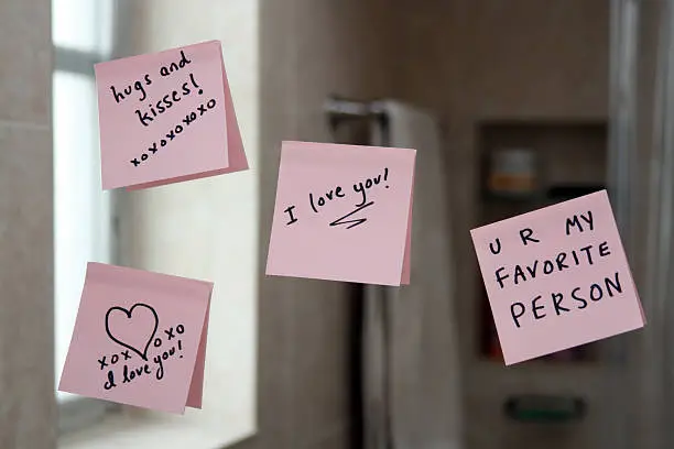 Photo of Love notes on sticky paper stuck up on a mirror