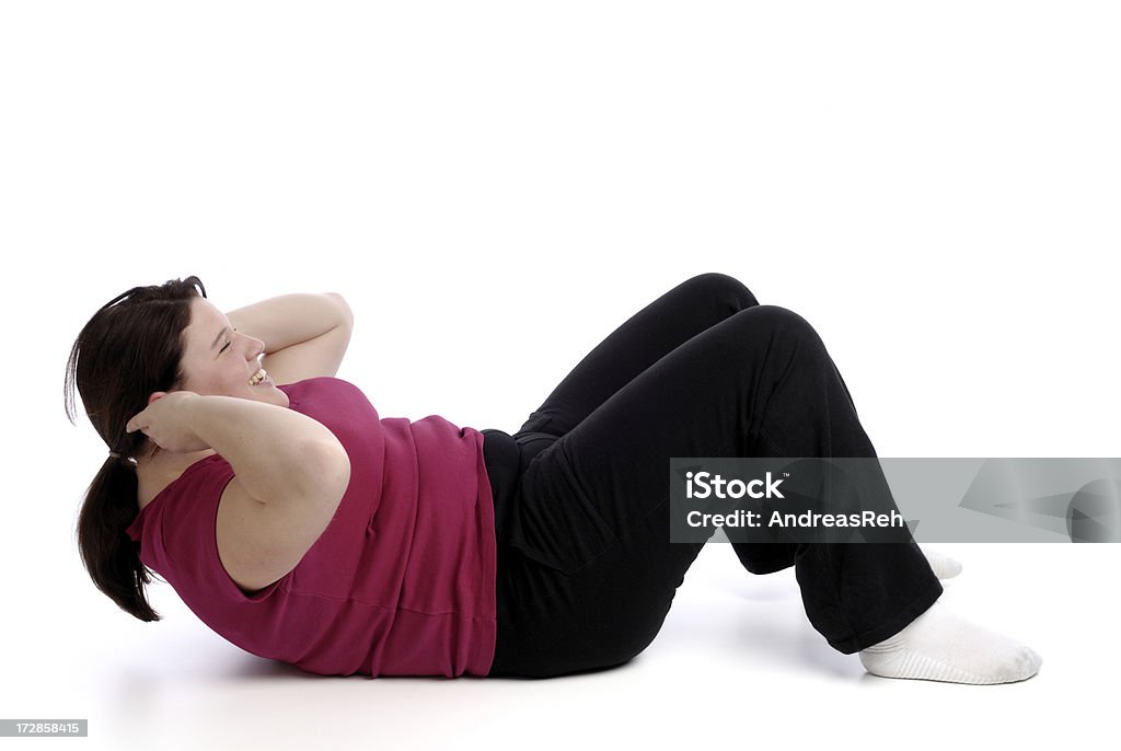 Sit-up Young woman at workout. More from this model in the lightbox: Overweight Stock Photo