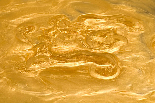 Liquid Gold "Metallic gold food coloring, flowing in wave patterns. Appears exactly like pure gold in the form of molten metal." melting metal stock pictures, royalty-free photos & images