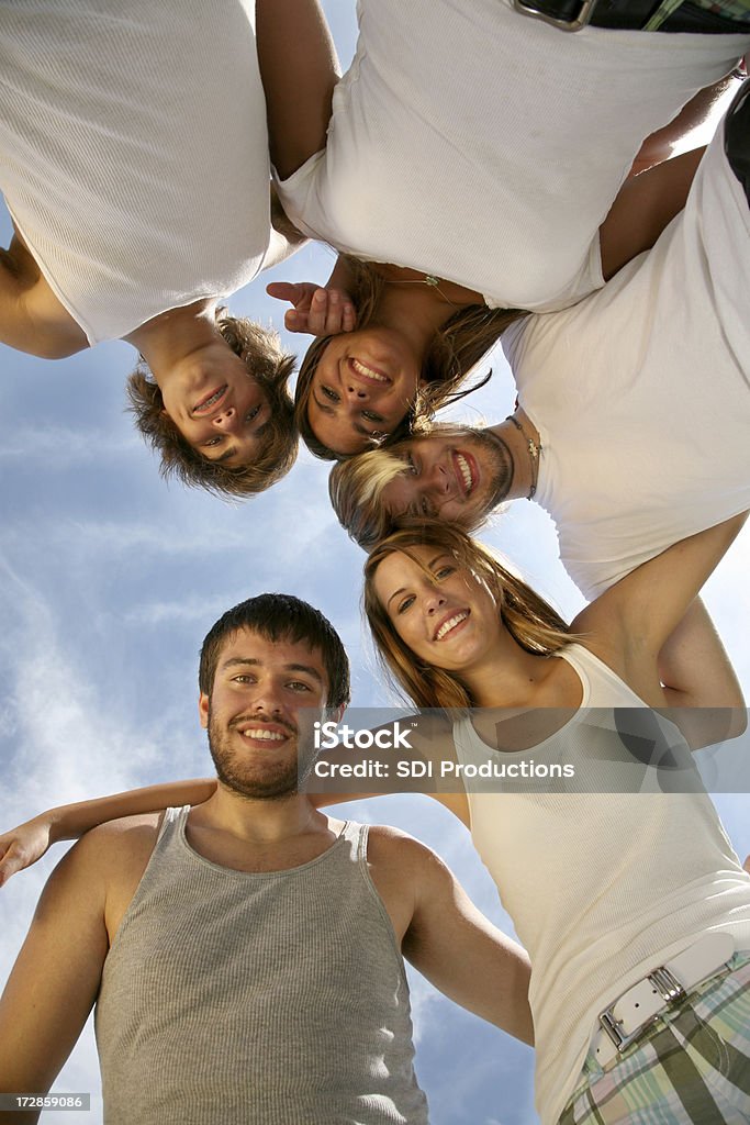 Gruppo di adolescenti rannicchiate insieme sotto il cielo blu - Foto stock royalty-free di Semicerchio