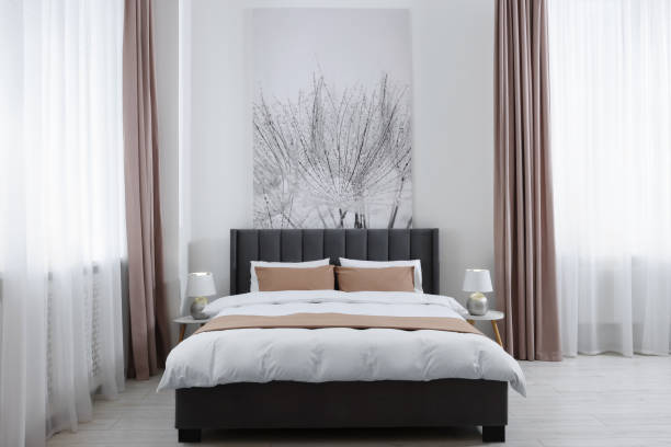 istock Comfortable bed and lamps on bedside tables in light spacious room. Stylish interior 1728596802