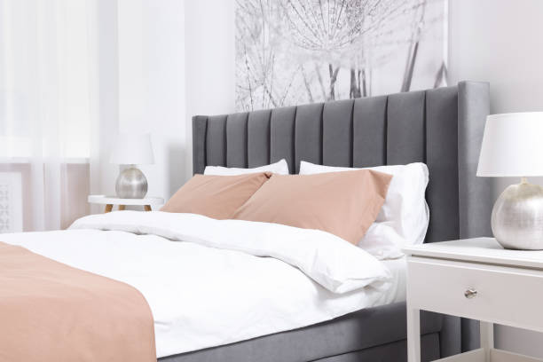 istock Comfortable bed and lamps on bedside tables in light room. Stylish interior 1728597318