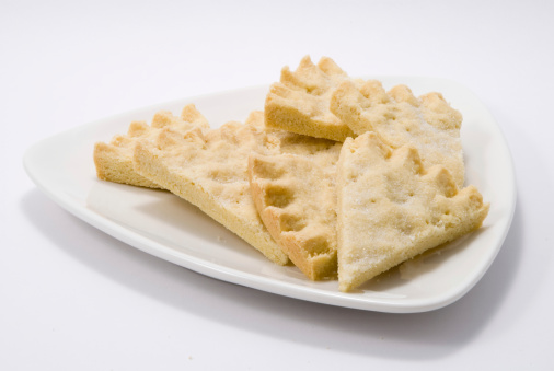 shortbread biscuits on a white triangular plate with a gold background