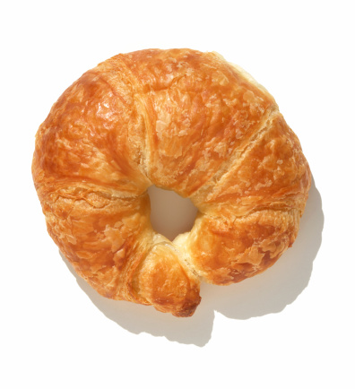 Directly above a plain croissant on white background.