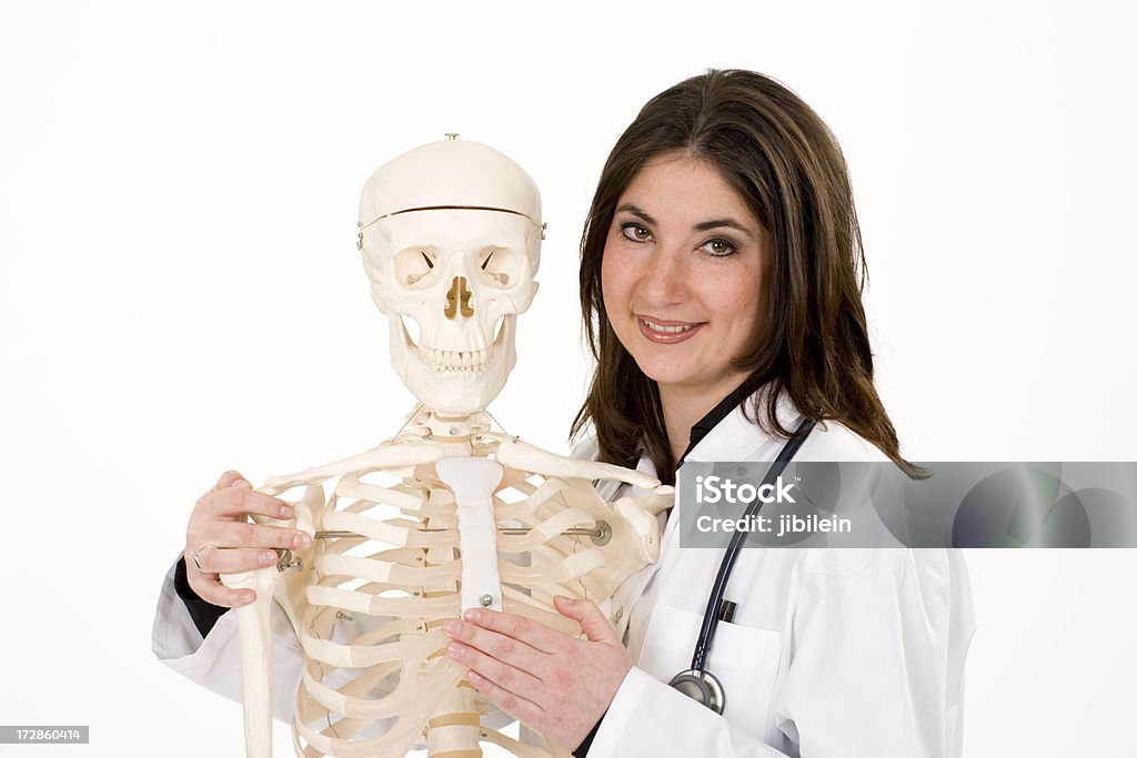 Alegre médico feminino com esqueleto horizontal - Foto de stock de Adulto royalty-free