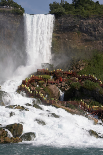 Tourists with raincoats enjoying the American Falls part of Niagara Falls.