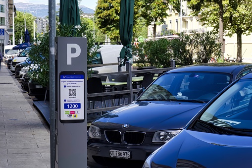 geneva, switzerland - 08 September 2022: a central parking meter has been placed on a city street for drivers to pay for parking