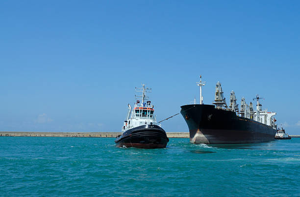 schlepper und container ship - tugboat towing nautical vessel industrial ship stock-fotos und bilder