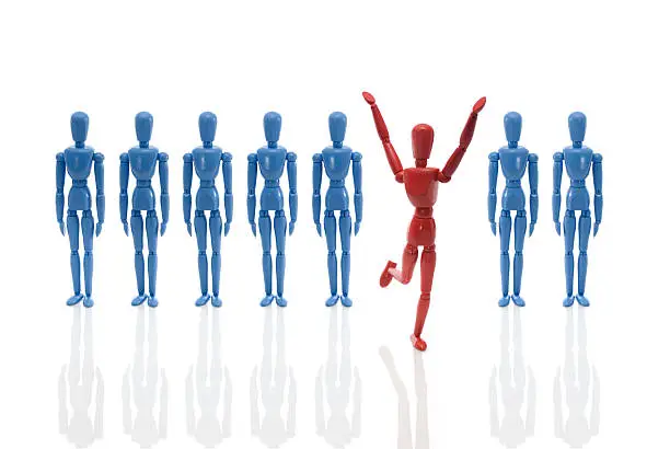 Human mannequin figure jumps out from a row of blue figures.
