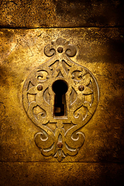Retro keyhole An old medieval keyhole on a gold / brass door with a rutsy ornate plate. keyhole stock pictures, royalty-free photos & images