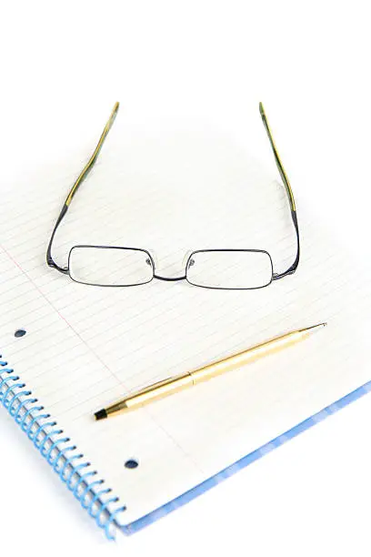 glasses and pen on a note-pad