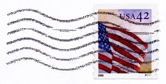 Canceled USA postage stamp showing the national Flag on an envelope.