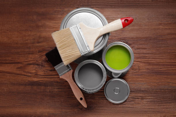 istock Cans of paints and brushes on wooden table, flat lay 1728629539