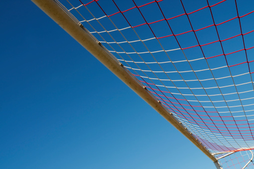Soccer goal net against blue sky.