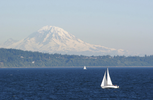 Telephoto shot of a sailboat on Puget Sound with Mt. Rainier in the far background