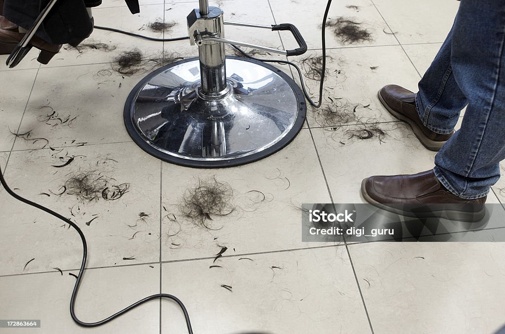 Haircut Aftermath Dark hair falls to the floor at a women's beauty salon during a haircut in progress. Flooring Stock Photo