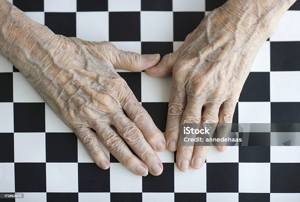 Old Hands Senior's hands photographed against a checkerboard tablecloth Adult Stock Photo