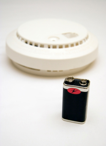 Smoke alarm with battery in foreground