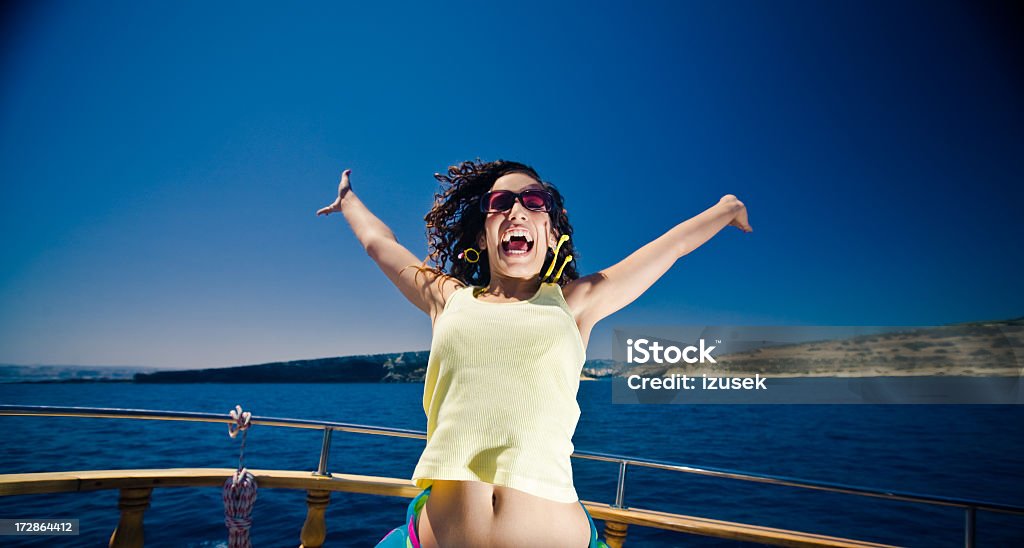 Young excited lady on a boat Young lady on a boat throws her arms in the air in excitement. 20-29 Years Stock Photo