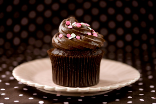 Chocolate cupcake with pink polka dot background and sprinkles.More of my cupcakes: