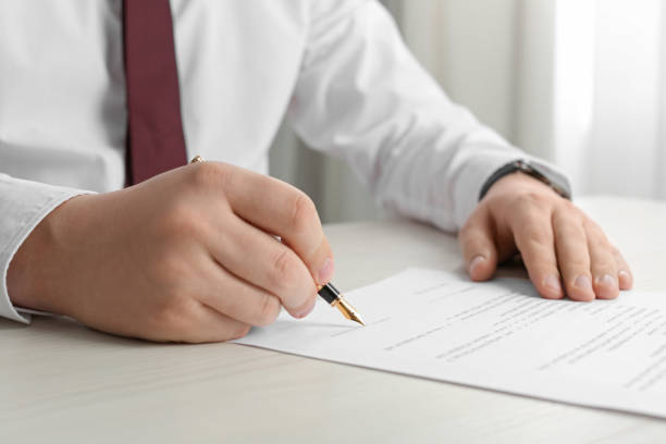 istock Notary signing document at wooden table indoors, closeup 1728647147