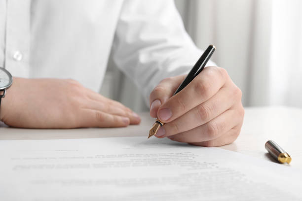 istock Notary signing document at wooden table indoors, closeup 1728648239