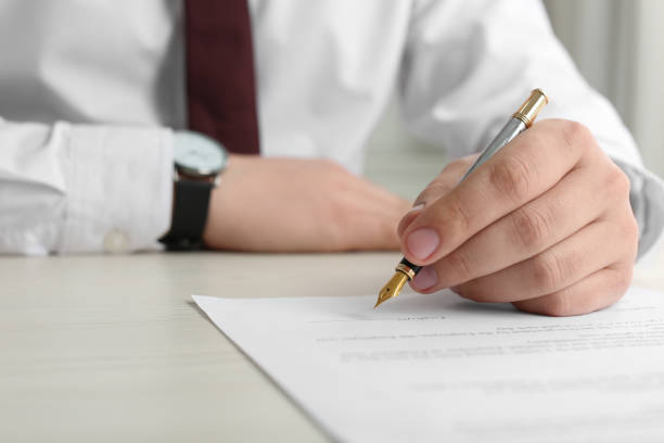 istock Notary signing document at wooden table, closeup 1728648248