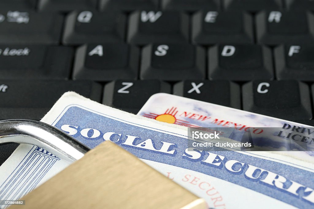 Online Security A lock with social security card and driver's license on a computer keyboard. Driver's License Stock Photo