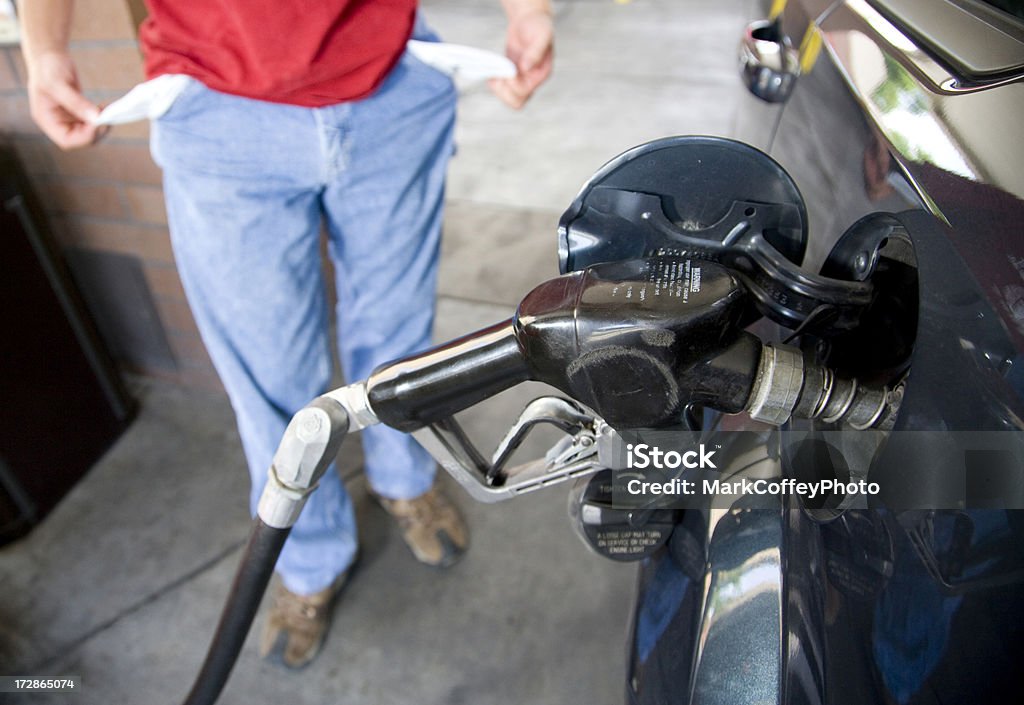 Gas prices leaving comsumers broke Man showing empty pockets after filling his car with gasoline. Adult Stock Photo